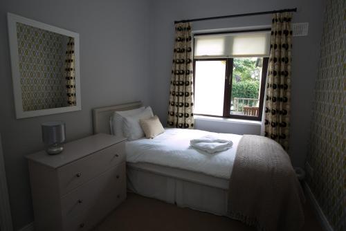 a small bedroom with a bed and a window at Cathedral View Apartments in Longford