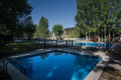una gran piscina en un parque con árboles en Camping & Bungalows Ligüerre de Cinca, en Ligüerre de Cinca