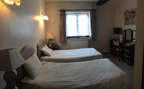 una camera d'albergo con due letti e una finestra di Sorrel Horse Inn a Ipswich