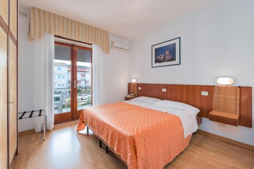 a bedroom with a bed and a large window at Hotel Helvetia in Grado