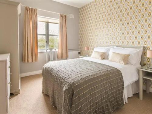 Un dormitorio con una cama grande y una ventana en Cathedral View Apartments en Longford