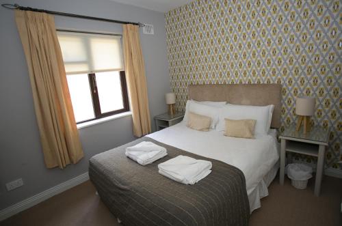 a bedroom with a bed with towels on it at Cathedral View Apartments in Longford