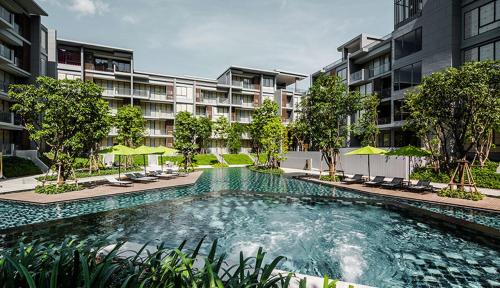 a swimming pool in front of a apartment building at The Valley Khao Yai-2 Bed Room in Ban Huai Sok Noi