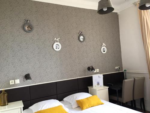 a bedroom with a bed and clocks on the wall at Hotel Chalet De L'isere in Cannes