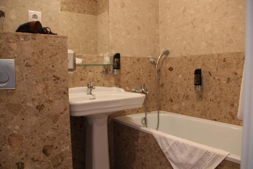 a bathroom with a sink and a bath tub at Luxury Garni Hotel Brix in Bratislava