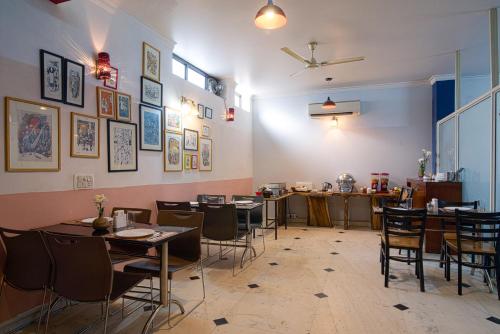 un restaurante con mesas y sillas en una habitación en Perch Arbor Suites, en Gurgaon