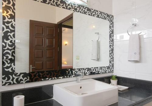 a bathroom with a sink and a mirror at Perch Arbor Suites in Gurgaon