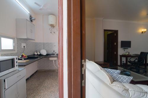 a room with a kitchen and a living room at Perch Arbor Suites in Gurgaon