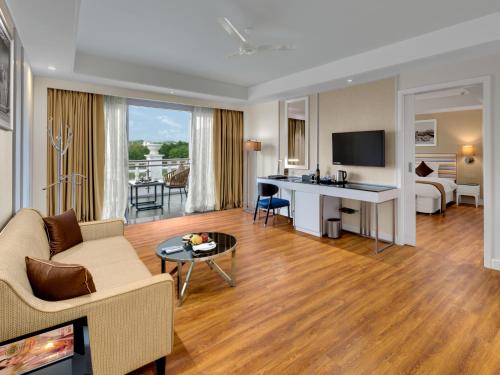 a living room with a couch and a table and a desk at Amanora The Fern Hotels & Club in Pune