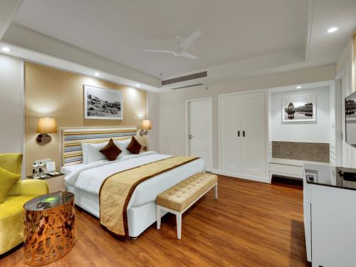 プネにあるAmanora The Fern Hotels & Clubのベッドルーム(大型ベッド1台、黄色いソファ付)