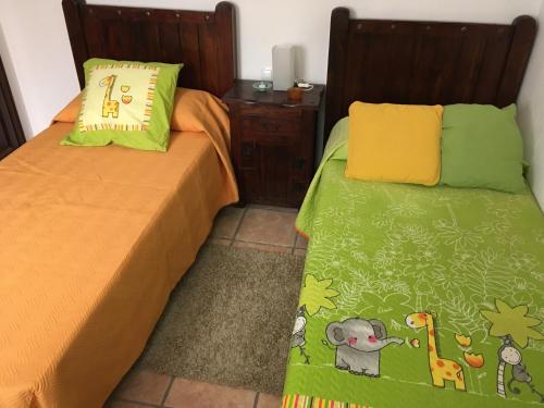 um quarto com 2 camas com lençóis verdes e amarelos em Casa Daniela em Arrecife