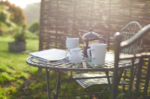 a small table with cups and plates on it at The Wheatsheaf Combe Hay in Bath