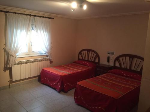 1 dormitorio con 2 camas y ventana en Yoanna, en Ciudad Rodrigo