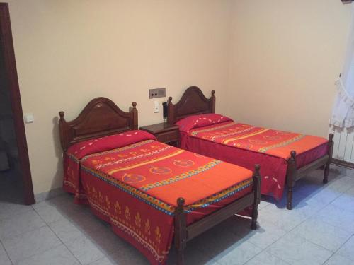 two beds with red covers in a room at Yoanna in Ciudad-Rodrigo