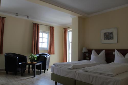 a hotel room with two beds and a table and chairs at Hotel Villa Passion in Malchow