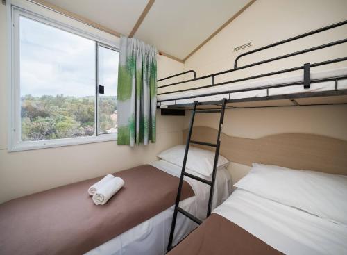 sypialnia z dwoma łóżkami piętrowymi i oknem w obiekcie Private Bay Residence w mieście Vrboska