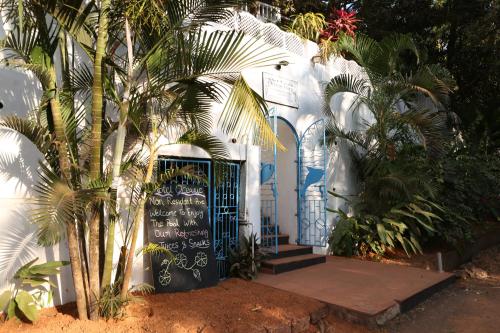a white building with a gate and palm trees at Oceanic - Luxury Boutique Hotel in Palolem