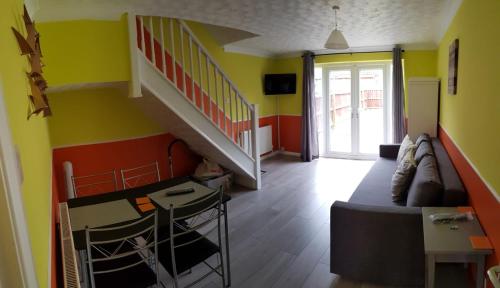 Columbine, Thetford, 2BR House في ثتفورد: غرفة بها أريكة وطاولة ودرج