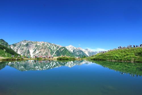 a body of water with mountains in the background at Hotel Hakuba in Hakuba