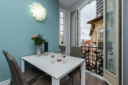 Una mesa blanca con copas de vino en un balcón. en Monte Carlo View, en Montecarlo