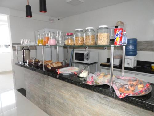 a kitchen with a counter with lots of food at Lider Hotel in Lavras