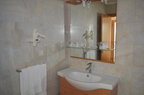 a bathroom with a sink and a mirror at Arenilha Guest House in Vila Real de Santo António