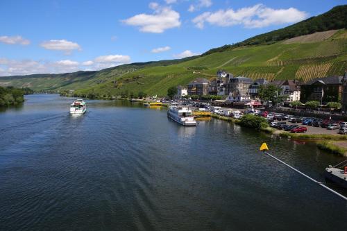 a river with boats docked in a town at Weingut Bastian in Brauneberg