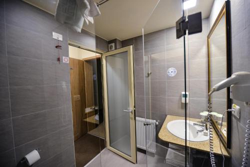 a bathroom with a sink and a shower at Hotel Posada Vidraru in Căpăţîneni-Ungureni