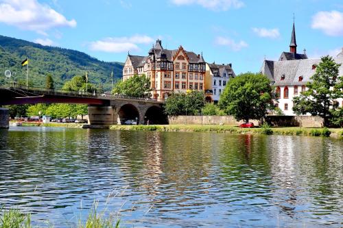 a bridge over a river in a city with buildings at Weingut Bastian in Brauneberg