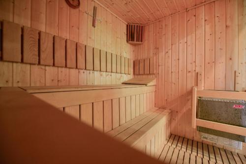 an empty sauna with pink walls and wooden floors at Hotel Posada Vidraru in Căpăţîneni-Ungureni