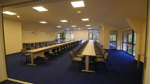 a long row of tables and chairs in a room at Hotel Posada Vidraru in Căpăţîneni-Ungureni
