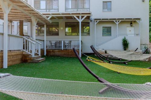 a house with two hammocks in front of it at Bait Alfa Kibbutz Country Lodging in Bet Alfa