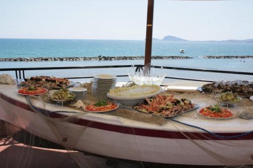 a table with many plates of food on top of the ocean at Grand Hotel Fagiano Palace in Formia