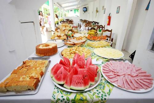 una mesa cubierta con muchos tipos diferentes de comida en Pousada Tapuia, en Porto Seguro