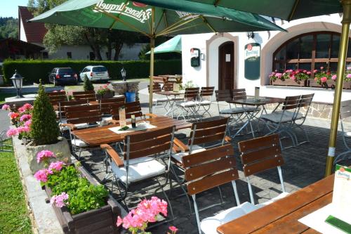 un grupo de mesas y sillas con sombrillas y flores en Hotel Jiřičná en Sušice