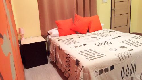 a bedroom with a large bed with orange pillows at Chill land house in Bang Tao Beach