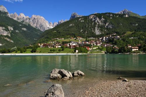 a lake in the mountains with rocks in the water at Alexander Hotel Alpine Wellness Dolomites in Molveno
