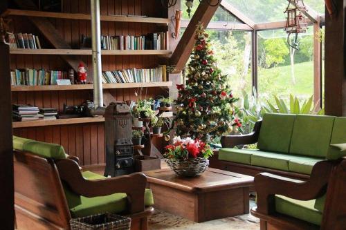 uma sala de estar com uma árvore de Natal num quarto em Pousada LindnerHof em Rio dos Cedros