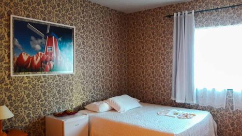 um quarto com uma cama e uma fotografia na parede em Hotel Pousada Oosterhuis em Castro