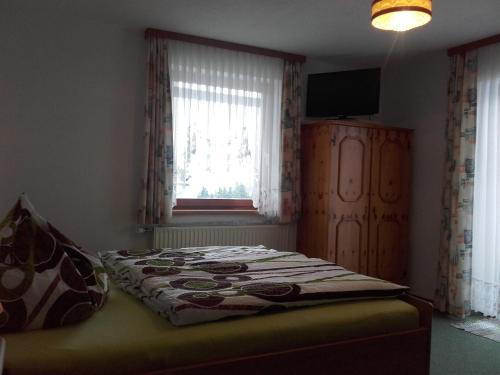 a bed sitting in a bedroom with a window at Rainzhof in Aich