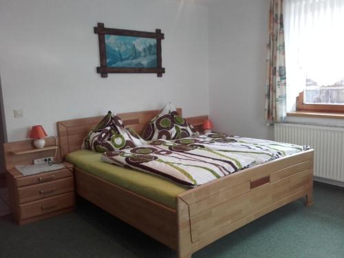 a bedroom with a bed with a wooden bed frame at Rainzhof in Aich