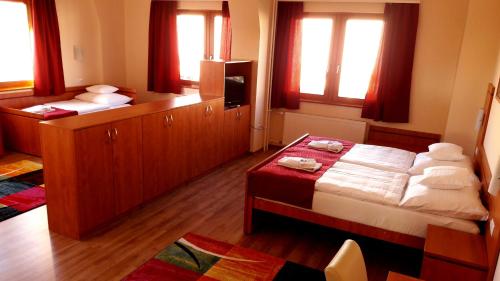 a bedroom with two beds with red curtains and windows at Diana Club Hotel in Budapest