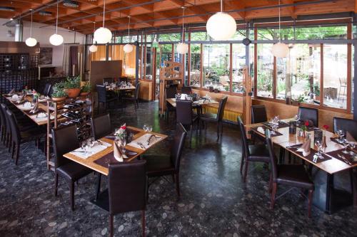 a restaurant with wooden tables and chairs and windows at Hotel Lifestyle in Landshut