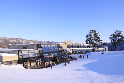 a group of people in the snow in front of a building at Hotel Hakuba in Hakuba