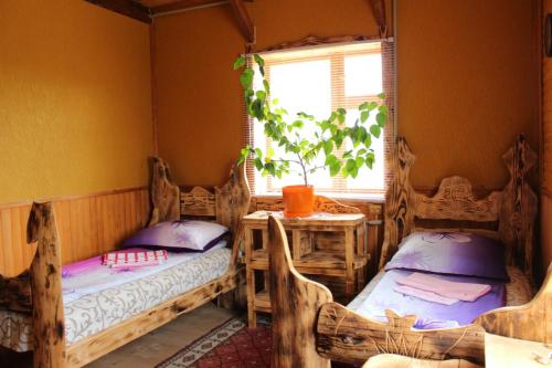 Cette chambre comprend 2 lits, une table et une fenêtre. dans l'établissement Skhovanka Dovbusha, à Myhove