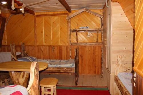 a room with a bed in a wooden cabin at Skhovanka Dovbusha in Migovo