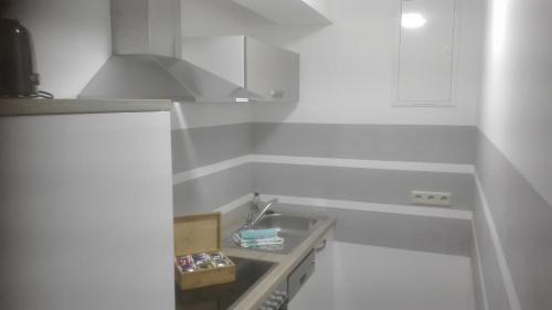 a white kitchen with a sink and a hood at Ferienwohnungen Paul und Dorothea in Döllstädt