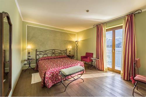 a bedroom with a bed and a large window at La Darsena Boutique Hotel & Restaurant in Tremezzo