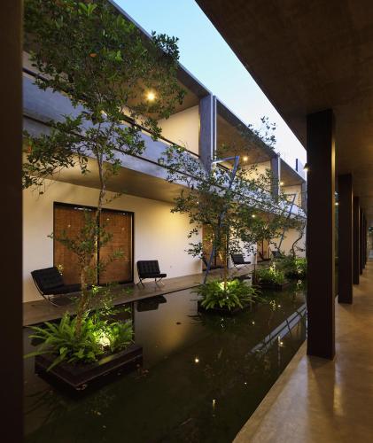 a building with a pond with trees in it at Serendiva Beach in Wadduwa