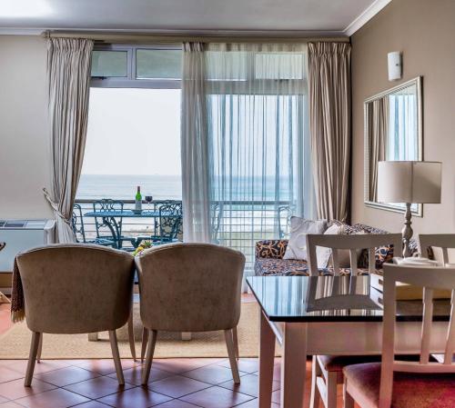 un soggiorno con tavolo e vista sull'oceano di Cape Town Beachfront Apartments at Leisure Bay a Città del Capo